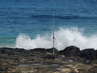 Fototapeta na wymiar Fishing pole alone on the rocks