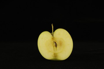 Apple or apples whole or sliced in half on black background.