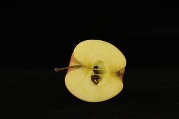 Apple or apples whole or sliced in half on black background.