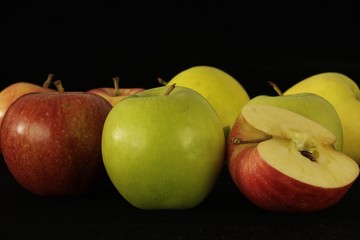 Apple or apples whole or sliced in half on black background.