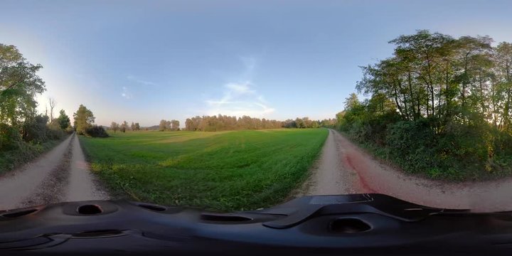 360VR video. Woman riding mountain bike at sunset