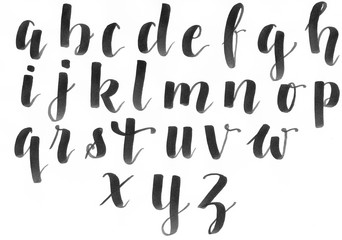 Hand lettering, modern calligraphy alphabet in black on a white paper, handwritten with a personal font