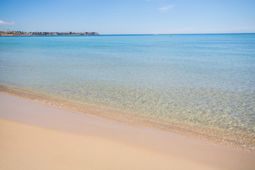 Sandy beach with calm water in Spain. Clear water at the Mediterranean Sea on a summer day in Campoamor
