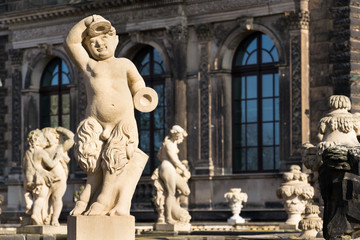 Fototapeta na wymiar Statues around Nymphenbad at baroque Zwinger palace in Dresden, Germany, sunny spring day
