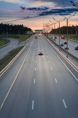 Highway Traffic at Sunset. asphalt road with metal safety barrier or rail