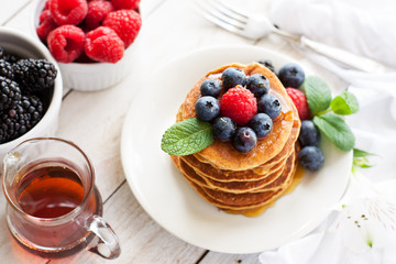 Paleo apple-cinnamon pancakes with berries, maple syrup