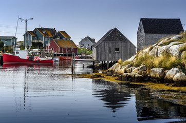 Idle day at Peggy's Cove - Fishing boat is idle and docked in the clam waters of Peggy's Cove on a...
