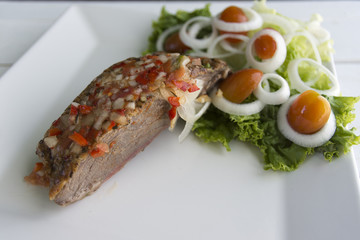 Meat with sauce of red pepper and onions with fresh salad with tomato lettuce and onions