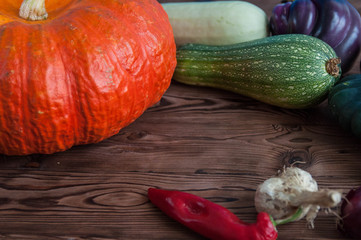 Autumn harvest of fruits and vegetables: pumpkin, eggplant, patisson, pepper, onion, garlic on wooden background
