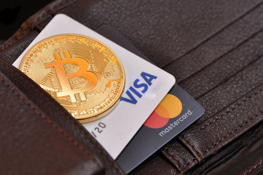 Rome, Italy, August 18, 2018. Bitcoin gold coin and debit cards Visa and MasterCard in a wallet leather