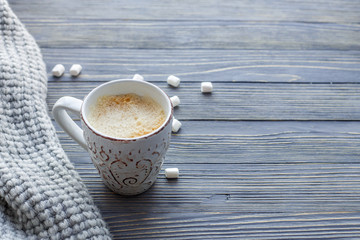 Cup of coffee with marshmallow on a wooden background. Copy space