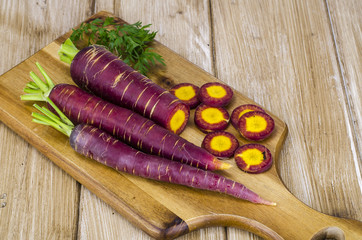 Sliced purple carrot on wooden background