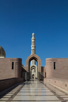 The marble floor leading to the entrance gate of the Sultan al Qaboos Grand mosque in Muscat, Sultanate of Oman, in the background, the minaret	