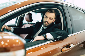 The man is looking in the rearview mirror. Portrait of an handsome confident businessman while...