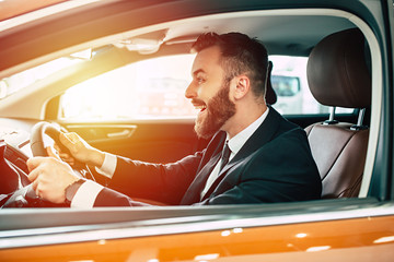 Naklejka premium Portrait of an handsome positive smiling business man driving his car