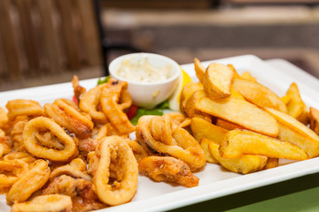 crispy calamari rings with french fries and sauce