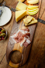 Delicious Meat and Cheese Board with Bread, Apple and Olives