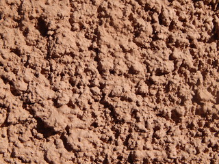 The wall, finished with brown plaster, the texture