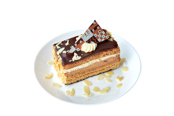 Piece of chocolate cake with almond and chocolate on white. Isolated. Round plate with almond. Close UP