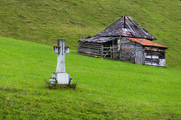 Cross and house in Romania mountain countryside