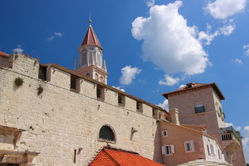 Trogir (Chorwacja) - zabytkowe zabudowania z jasnego wapienia przy bulwarze nad brzegiem Adriatyku z widoczną wieżą kościoła świętego Mikołaja.