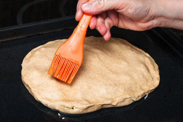 oiling the crust of raw pie by silicone brush