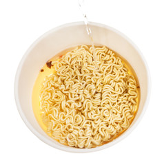 pouring hot water into cup with instant noodles