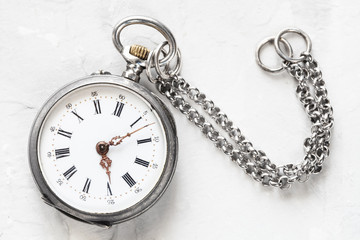 vintage pocket watch with chain on white plaster
