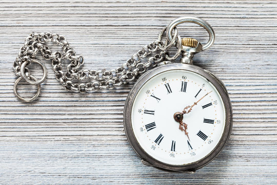 retro pocket watch with chain on gray table