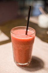 a glass of smoothie made from raspberries and oranges