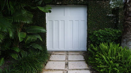 White gate door to a tropical garden