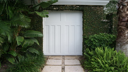 White gate door to a tropical garden