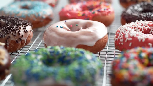 Sprinkling candy chocolate on frosted doughnut. Shot with high speed camera, phantom flex 4K. Slow Motion.