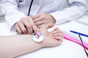 The doctor listens to the pulse and records