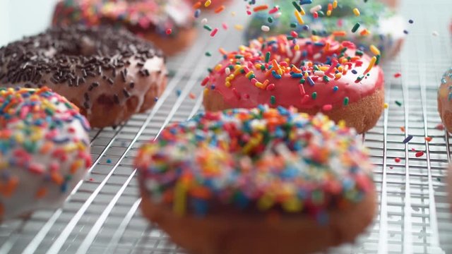 Sprinkling candy chocolate on frosted doughnut. Shot with high speed camera, phantom flex 4K. Slow Motion.