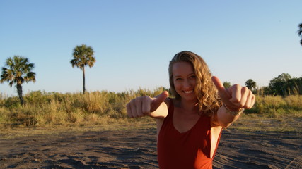 Portrait of a beautiful young blonde woman model smiling and showing thumbs up