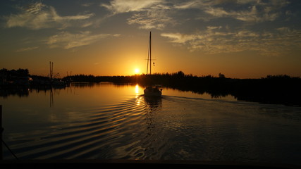 Fototapeta premium Sailboat heading out to the sunset