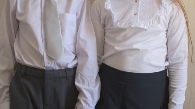 Close-up portrait of happy children with blue eyes and blond hair in school uniform. Boy and girl preschoolers on wind. Breeze plays with girl's hair and clothers. Old vintage style. Shallow focus