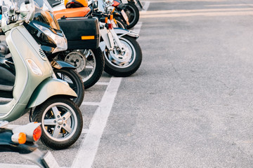 Parked motor scooters in the parking lot.
