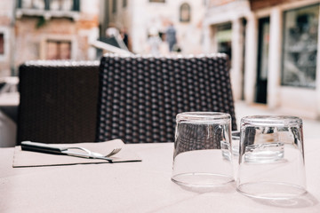 A table of a street and summer cafe with cutlery with a plant on the table.