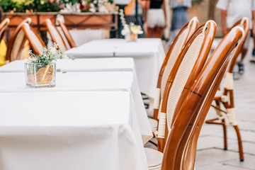 Serving tables of the summer cafe-restaurant on the city street.