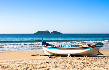 Fototapeta na wymiar Praia com barco de pesca artesanal