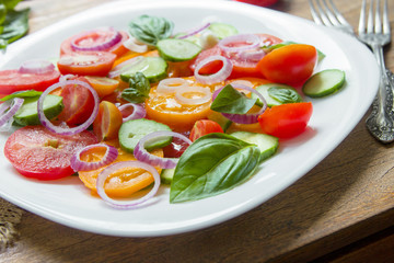 Sliced heirloom tomatoes, crisp cucumbers with chopped red onion, chives drizzled with olive oil...