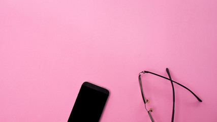 Minimal workplace with smartphone and  glasses copy space on pastel background. Top view. Flat lay.