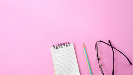 Minimal workplace with notebook and  glasses copy space on pastel background. Top view. Flat lay.