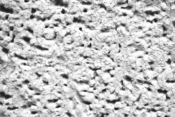 Detailed imperfect white texture of aerated foam block with holes close-up. Side of building is painted whitish. Background of construction from foamed material in macro. Decorative facing of house.