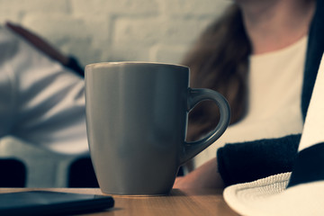 On a table there is a cup of coffee.