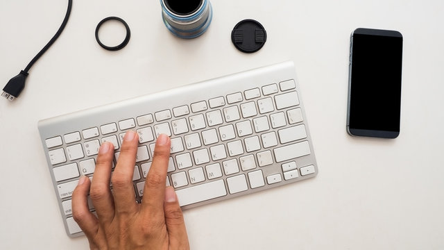 Top View Of Photographer Work Station With Hand Hold On White Background