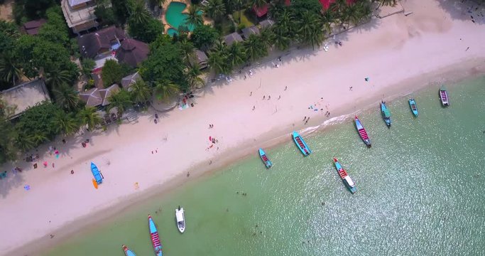 Aerial : Static shot,thai long tail taxi boats parking along the sand beach ,Bottle beach,koh Phangan island,Thailand