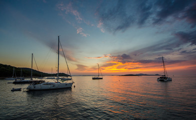 Obraz na płótnie Canvas Sail boats anchored in bay in sunset light